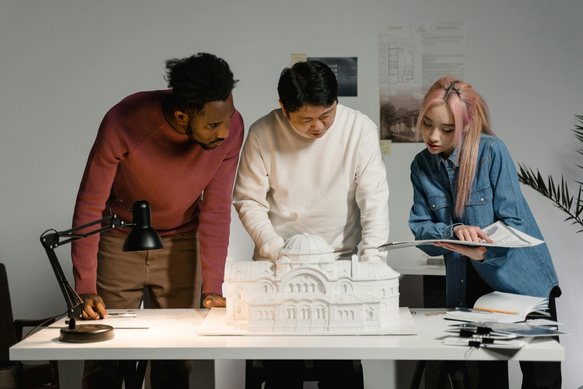 Ontwerpers in overleg rond een maquette van een ontwerp